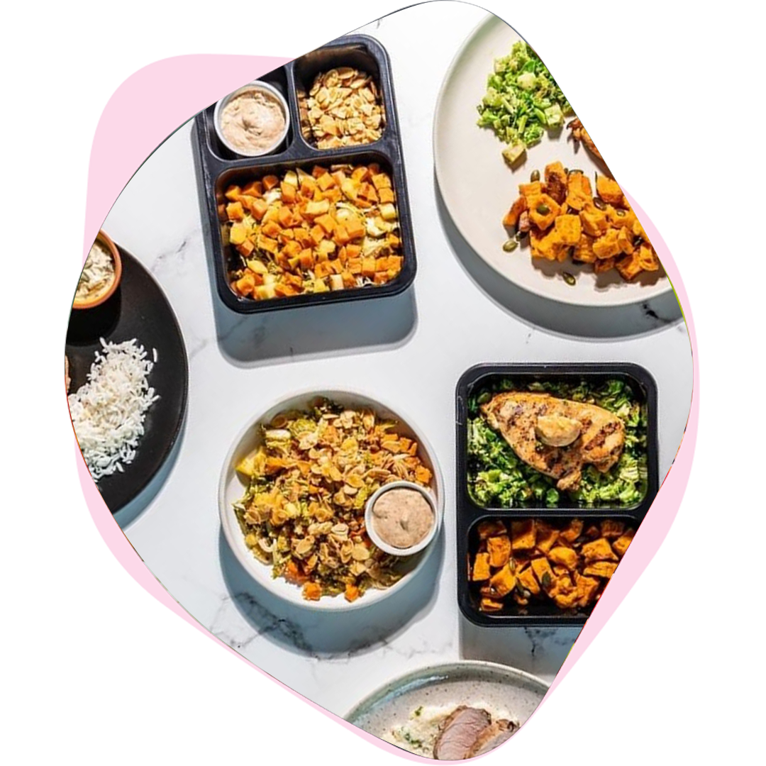 Meals in containers and bowls on a marble table, seen from above